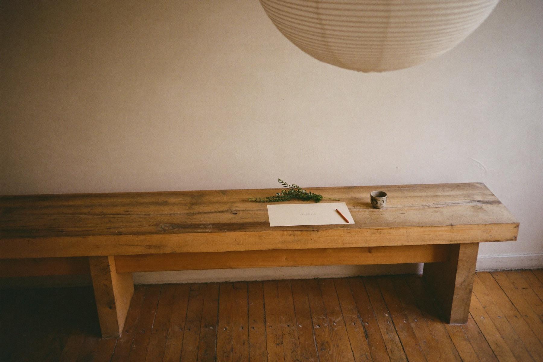 A handwritten care guide resting on the long communal timber bench